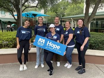Associates wearing Raymond James Cares shirts hold 